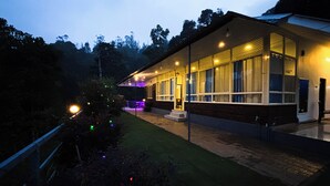 Un edificio moderno con un portico coperto, ampie finestre e un prato curato.