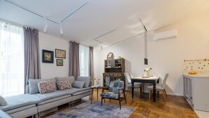 Una sala de estar moderna con un sofá, una mesa de comedor y una zona de cocina.