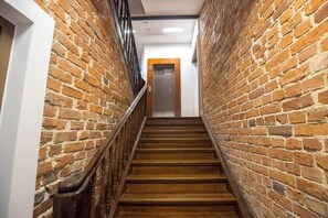 Eine Holztreppe mit Backsteinwänden und einem Holnänder.