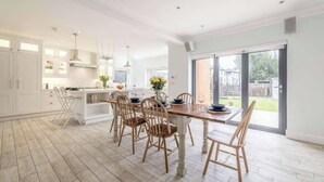 A spacious kitchen with a dining area, large windows, and a view of the backyard.