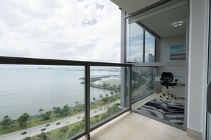 A high-rise apartment with a large balcony, a city view, and a modern office setup. - Exclusive and luxury 2BR with balcony in Yoo Panama (Panamá)