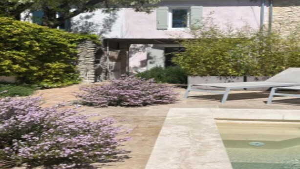 A stone house with a pool, surrounded by flowering bushes and a pergola. - Charming 18th-Century Townhouse with Private Terrace & Pool (Saint-Rémy-de-Provence)