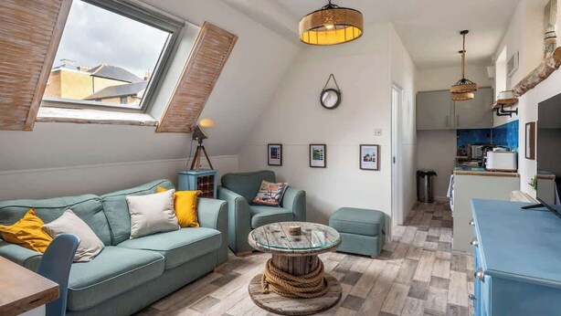 Un espacio habitable tipo loft con techo alto, zona de comedor y cocina.