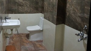 A bathroom with a sink, toilet, and shower. - HOTEL RAJDEEP (Sehore)