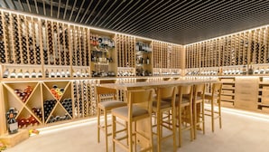 Une cave à vin avec des étagères en bois et un coin bar.