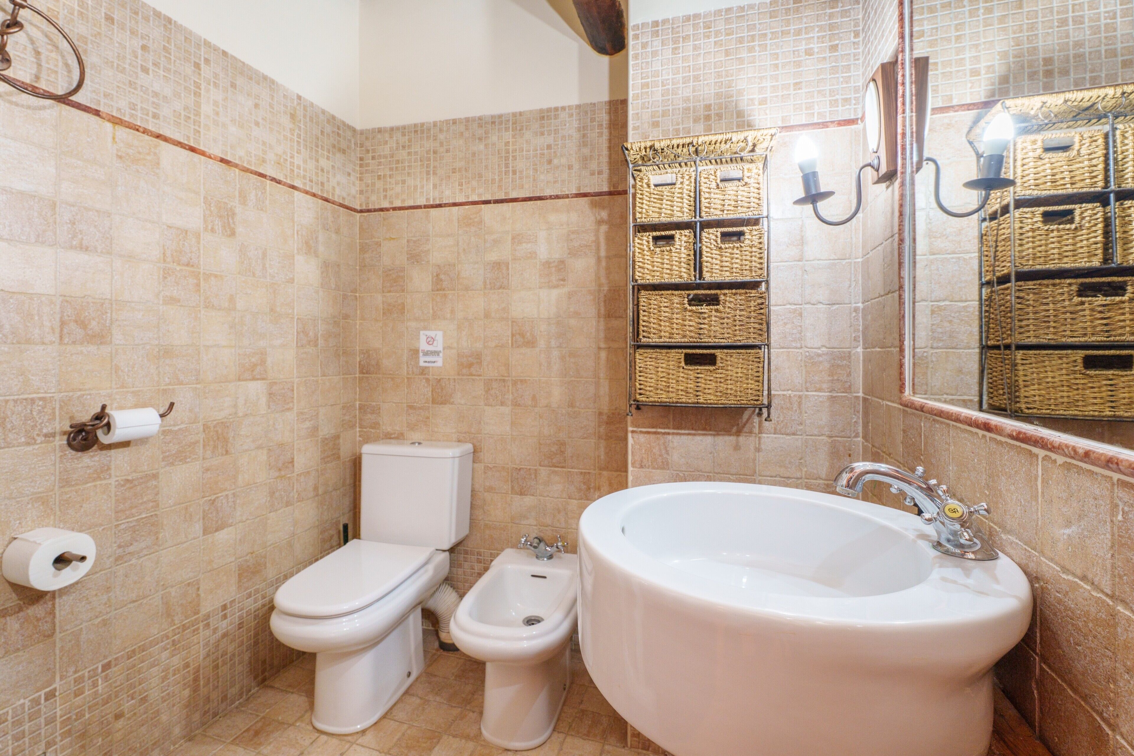 A bathroom with a toilet, bidet, and bathtub.