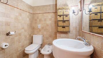 A bathroom with a toilet, bidet, and bathtub.