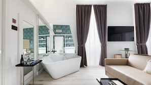 Une salle de bain moderne avec une baignoire sur pieds, une douche à parois de verre et un meuble-lavabo avec un miroir.