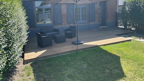 A patio area with outdoor furniture and a large umbrella.