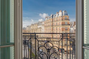 A balcony with wrought iron railings overlooking a row of historic buildings. - Paris Les Amandiers Residence (Paris)