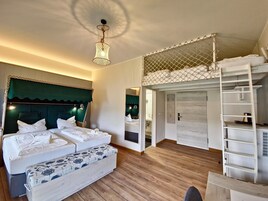 Un dormitorio con una cama grande, un banco, una escalera y un armario.