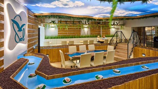 Een modern restaurant met een houten inrichting, een pooltafel en een zithoek met tafels en stoelen.