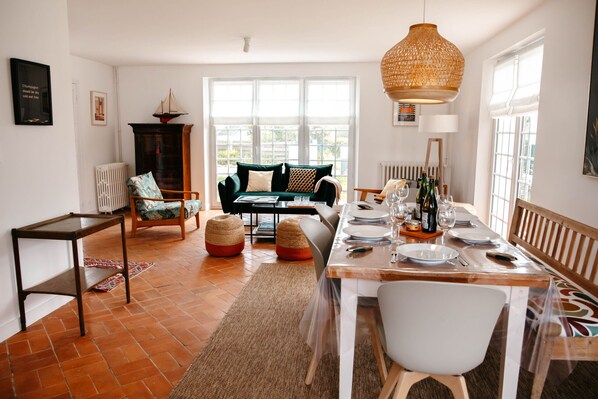 A dining area with a wooden table set for a meal, a sofa, and a chair.