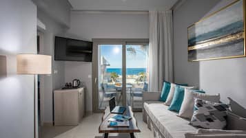 A modern living room with a sofa, coffee table, and a view of the ocean through a sliding glass door.