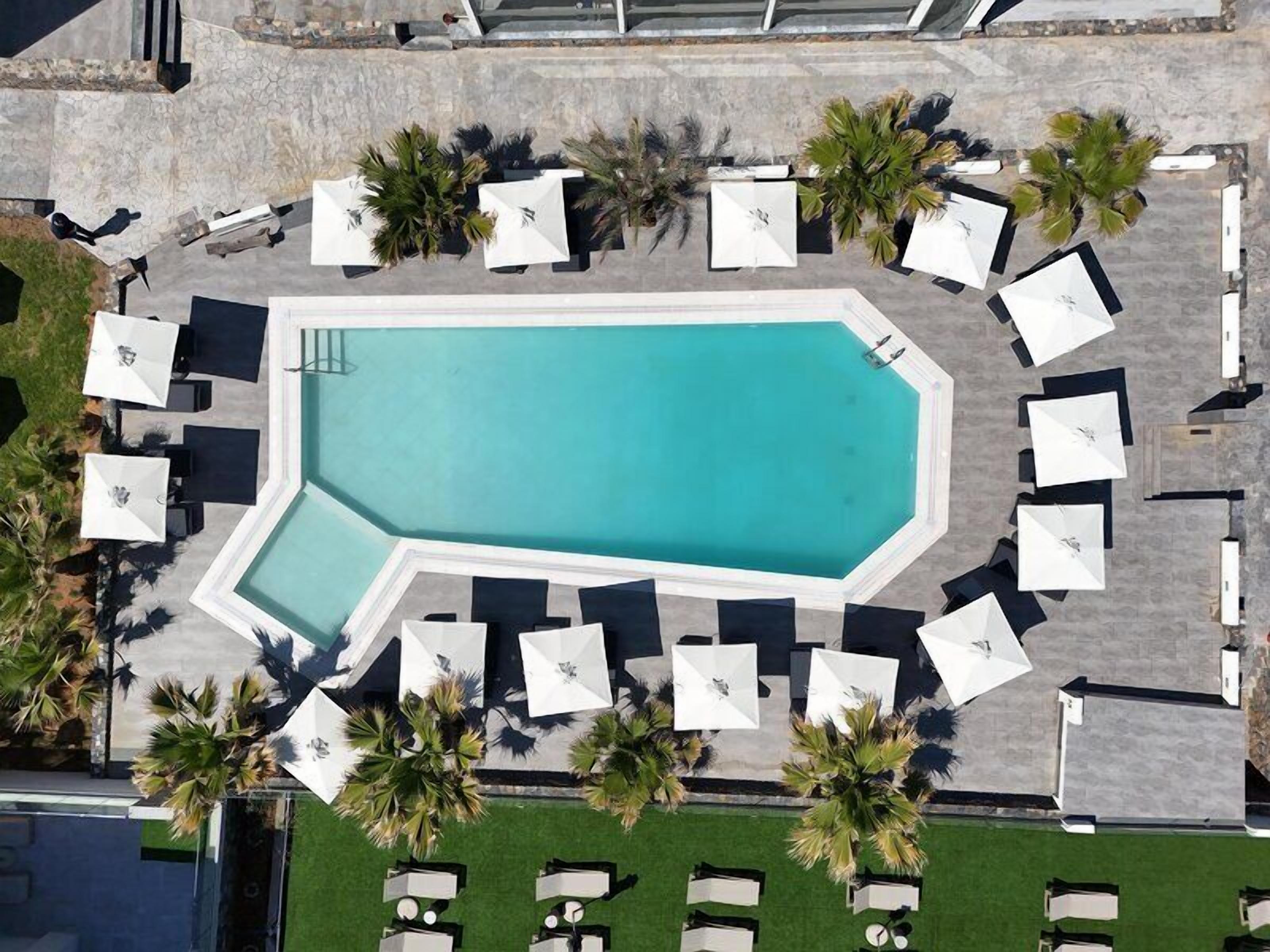 Una piscina al aire libre de temporada, sombrillas