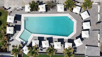 Una piscina al aire libre de temporada, sombrillas