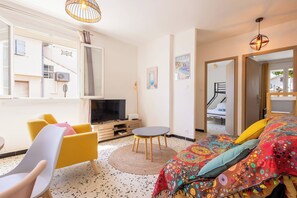 A modern bedroom with a bed, a TV, a chair, a small table, and a mirror. - Title Valras-Loc Cosy Apartment 150m from the Beach (Valras-Plage)