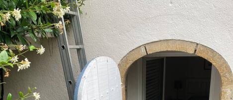 A white door with a metal handle, leading into a room with a wooden floor and a patterned rug.