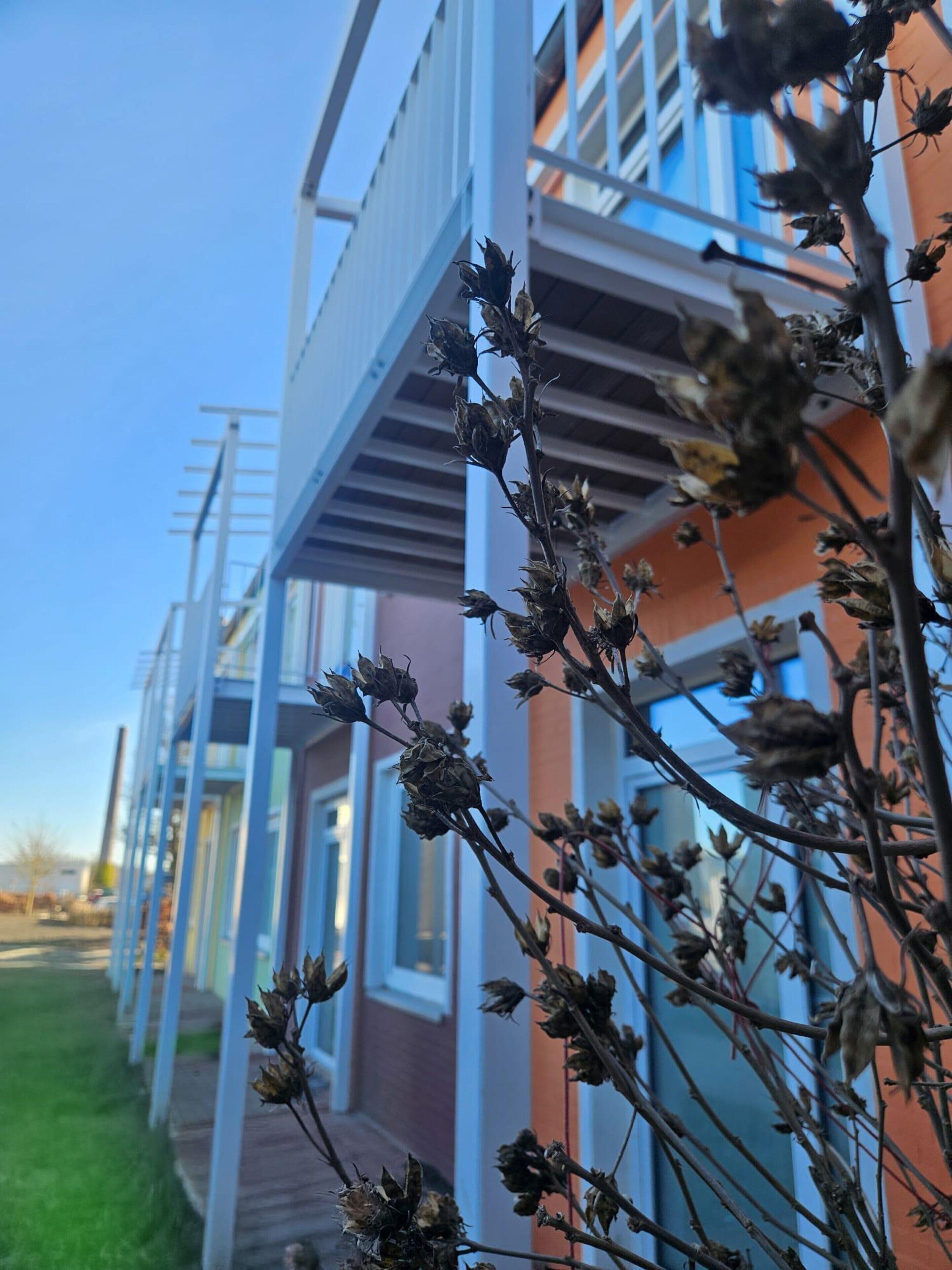 A row of modern buildings with balconies and a clear sky.