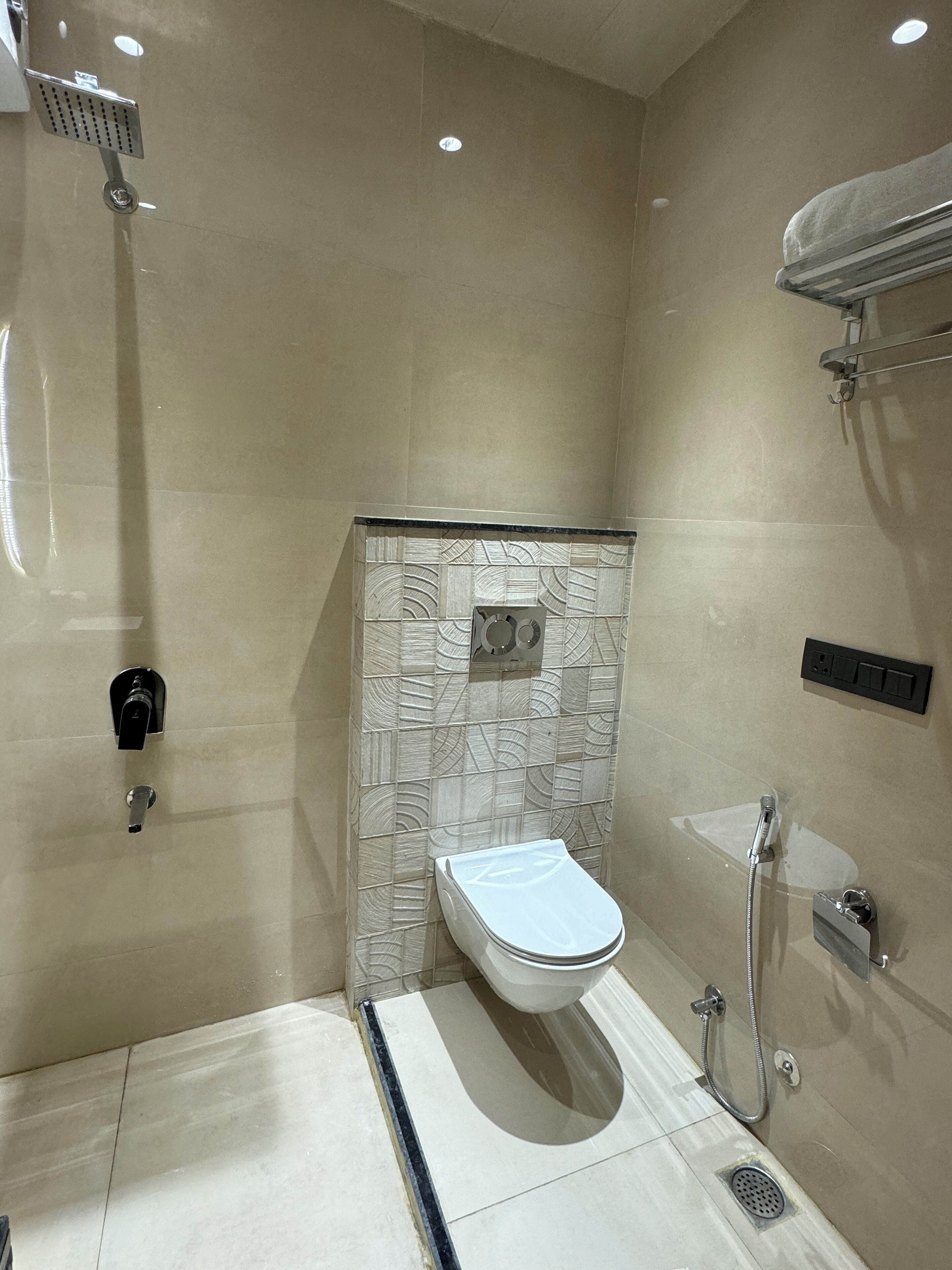 A modern bathroom with a toilet, shower, and sink.