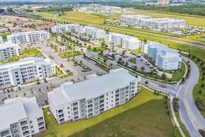 A modern residential complex with multiple apartment buildings, parking areas, and green spaces.
