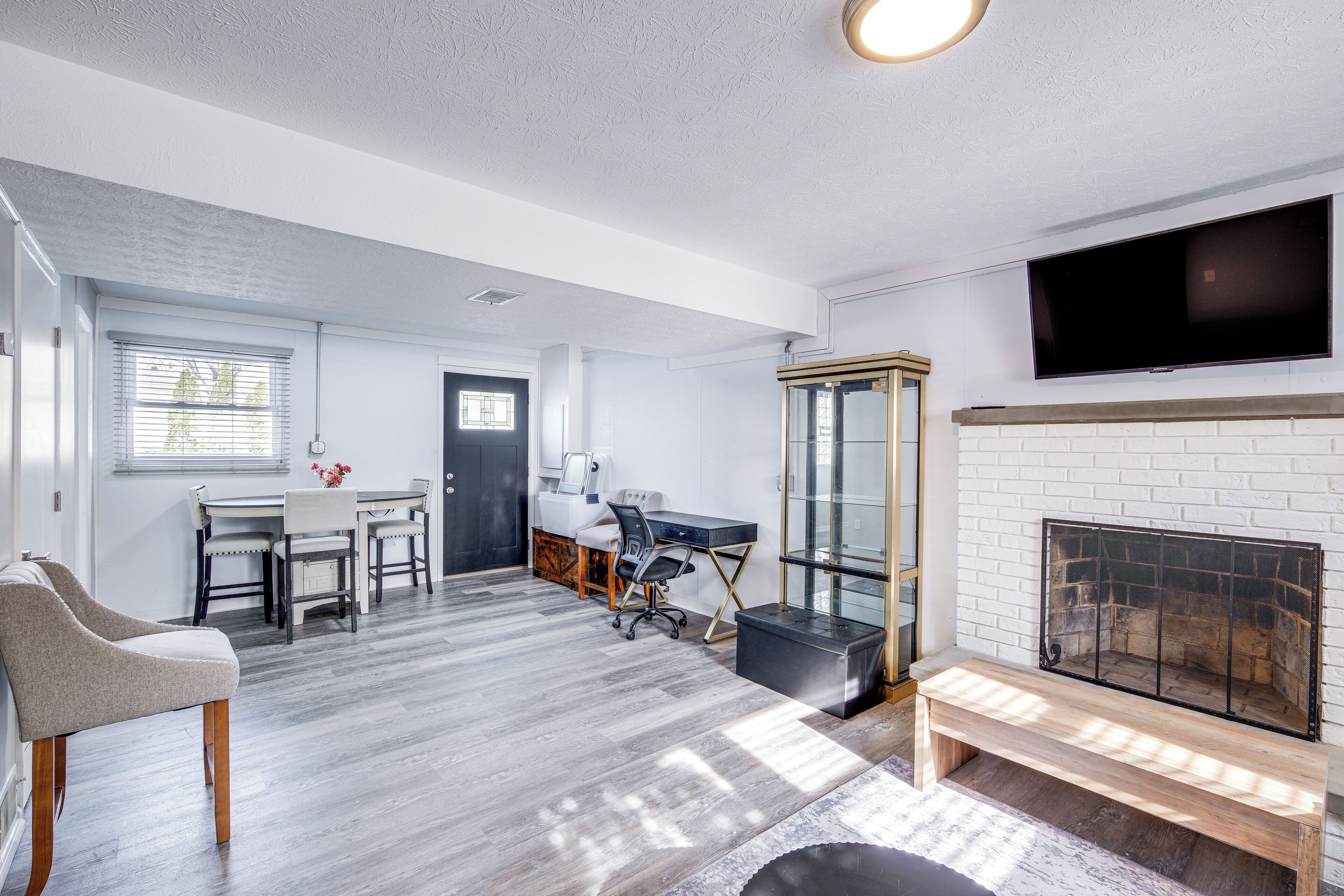 A spacious living room with a fireplace, a dining area, and a TV mounted on the wall.