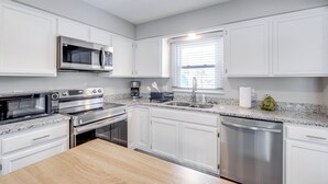A modern kitchen with white cabinetry, stainless steel appliances, a granite countertop, and a window with blinds. - 3 Mi to Cuyahoga Valley NP: Fairlawn Family Home! (Akron)