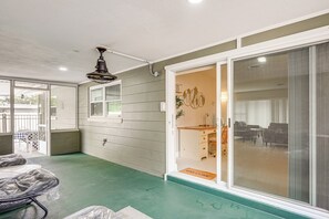 Enjoy a room with a balcony offering views of the outdoors, a ceiling fan, and a comfortable seating area.