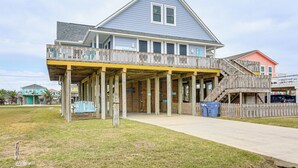 A two-story building with a balcony and a covered porch area. - Near Surfside Jetty County Park: Home w/ Deck! (Freeport)