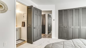 A bedroom with a bed, a wardrobe, and a bathroom with a towel hanging on the wall. - 3 Mi to Dtwn Alpena: Family Home w/ Yard! (Alpena)