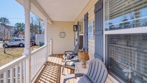 A covered porch with a white railing, two gray chairs, a wicker table, and a decorative lamp. - 1 Mi to Colonial Beach Boardwalk: Home w/ Fire Pit (Colonial Beach)