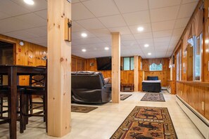 A wooden interior with a sofa, a dining table, and a rug. - Lakefront Home w/ Seasonal Dock in Limerick! (Limerick)