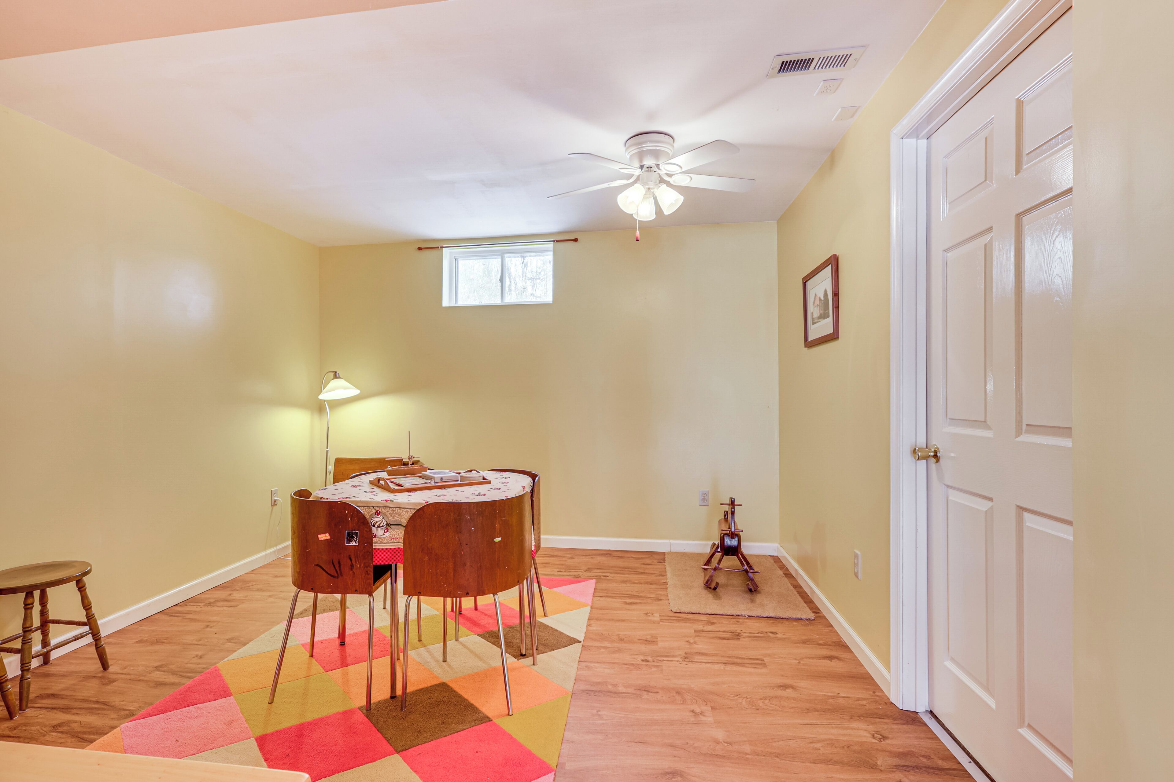 A dining area with a table, chairs, and a ceiling fan.