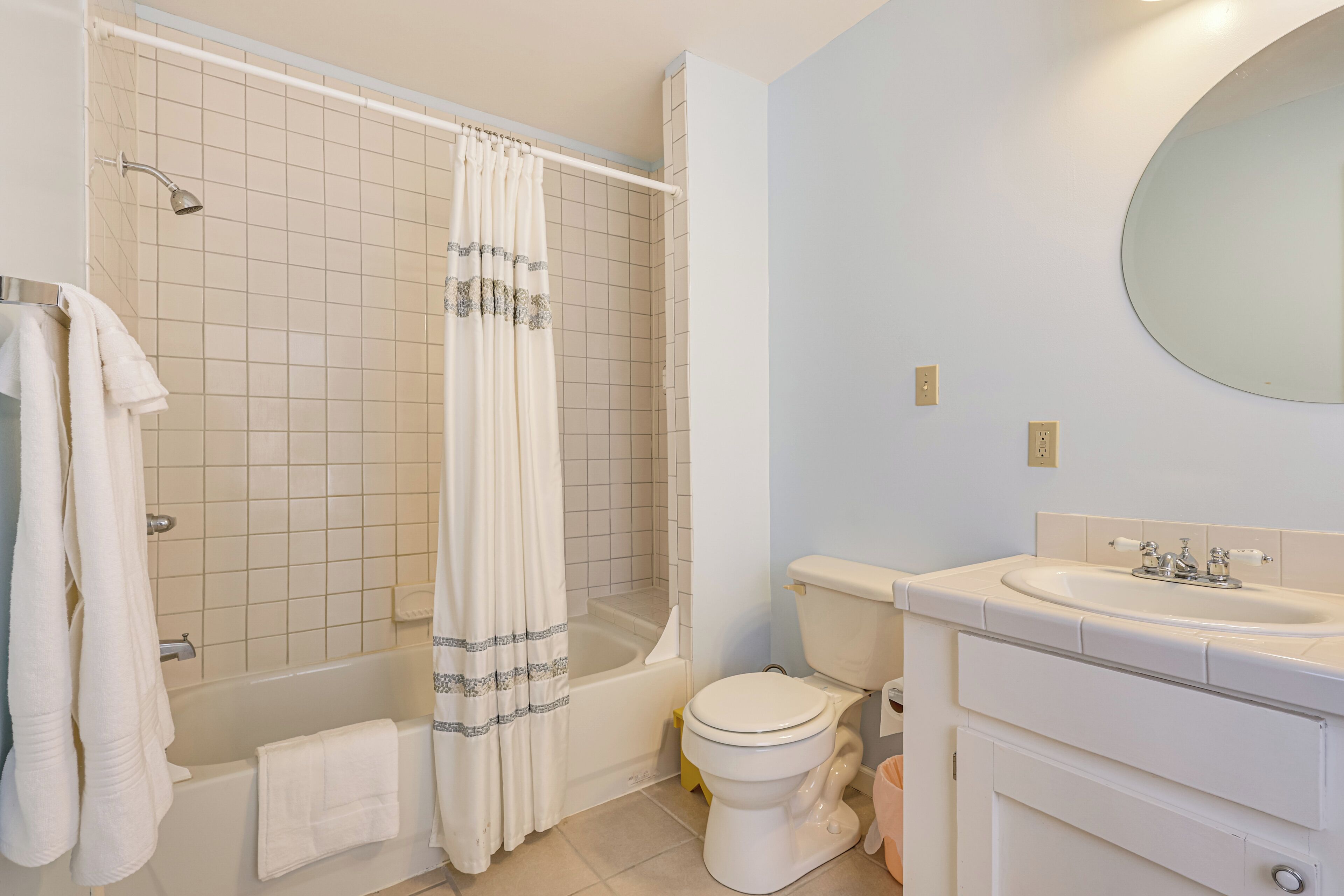 A bathroom with a bathtub, toilet, and sink.