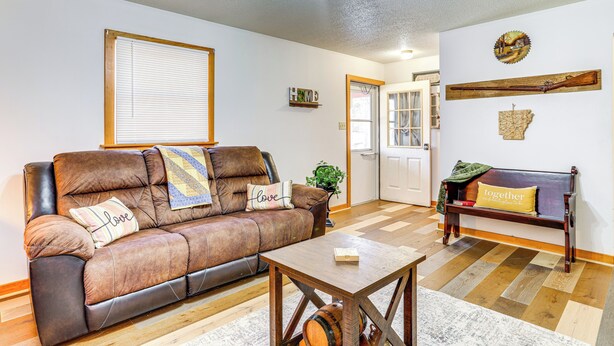 A living room with a brown leather sofa, a wooden coffee table, and a bench with a 'together' pillow. - 1 Mi to Dtwn Mountain View: Home w/ Deck (Mountain View)