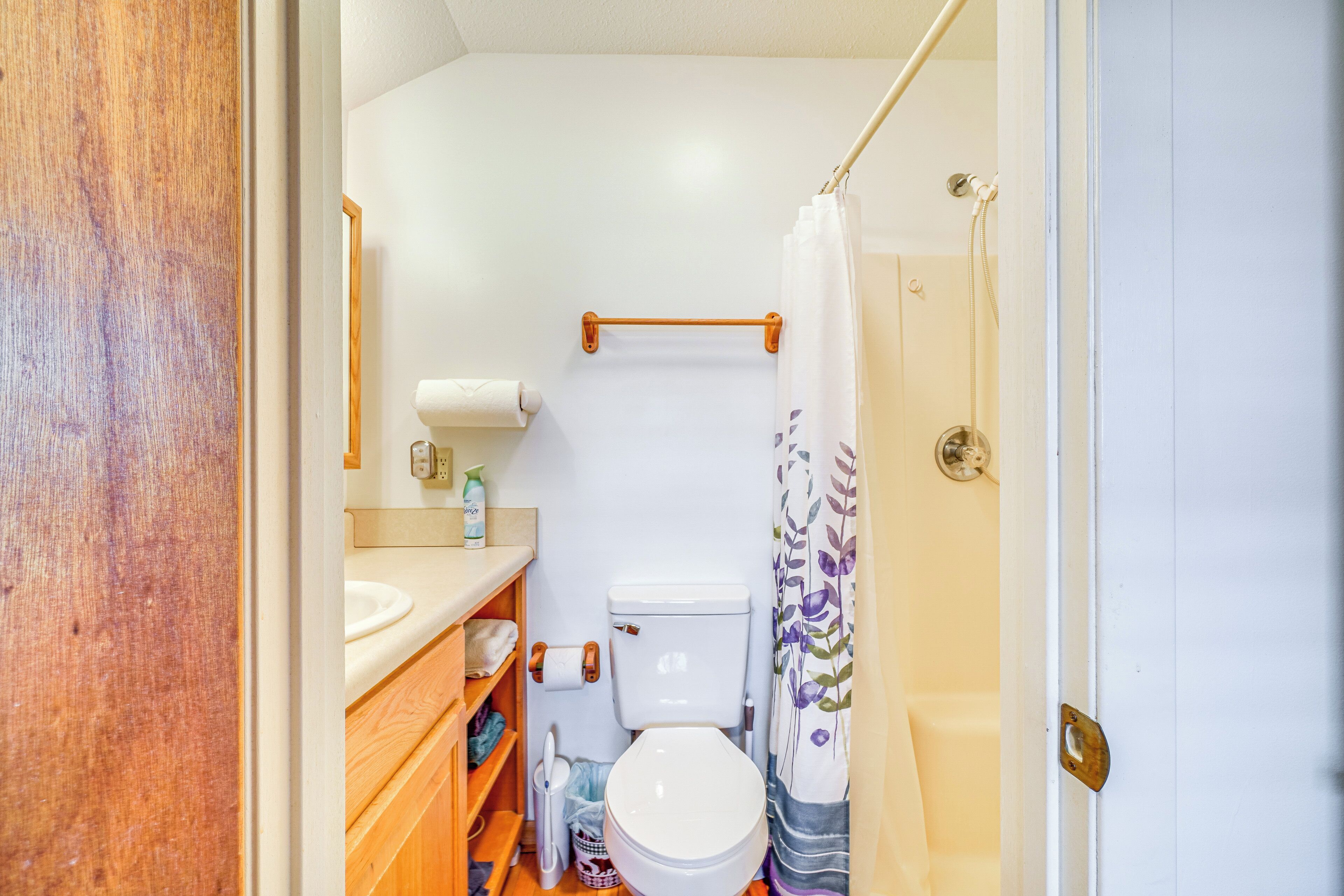 A compact bathroom with a toilet, sink, and shower area.