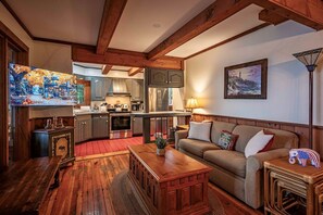 A cozy living room with a wooden coffee table, a sofa, and a television. - Ramona Point on 4th Lake & Trail 5 (Old Forge)