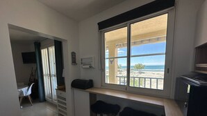 Eine kleine Küchenzeile mit Blick auf einen Strand.