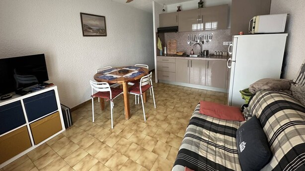 Ein kompakter Wohnbereich mit Essplatz, Küchenzeile und Sofa.