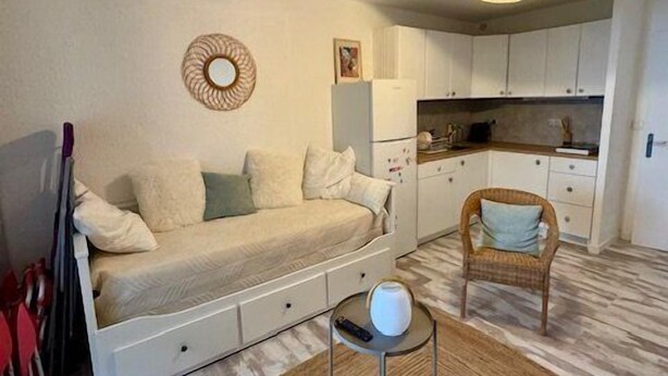 A compact living space with a sofa bed, a dining area, and a kitchen. - Studio-type apartment with terrace and parking space (SAINTES MARIES DE LA MER)