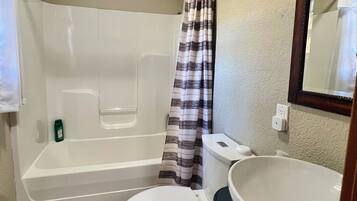 Une salle de bain avec une baignoire, des toilettes et un lavabo.