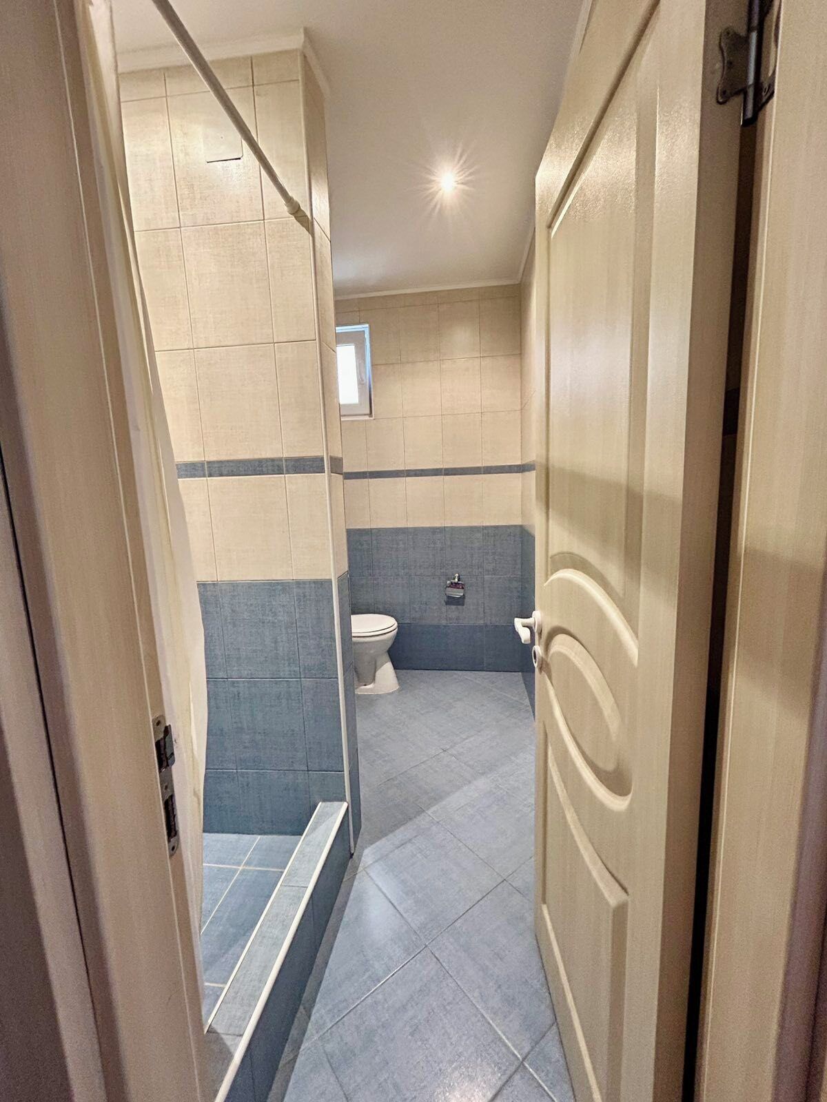 A bathroom with a toilet, a shower, and a sink.