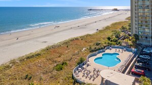 A beach view with a pool and lounge chairs, a pier in the background, and a hotel building. - W Hyde Pk 19A in Kingston 1st floor, Pool, Beach (Myrtle Beach)