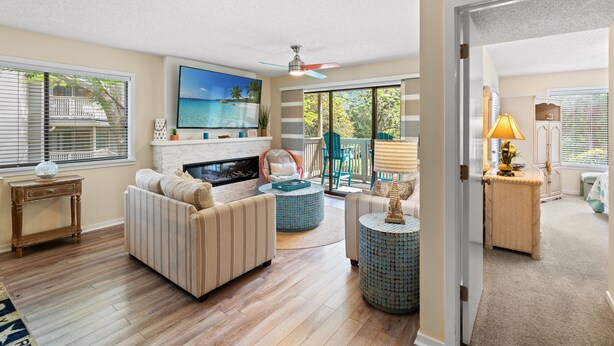 A spacious living room with a fireplace, a large TV, and a balcony with a view of the ocean. - W Hyde Pk 19A in Kingston 1st floor, Pool, Beach (Myrtle Beach)