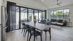 A spacious living area with a dining table, chairs, a sofa, and a ceiling fan. - Private Cardiff Beach House (Encinitas)