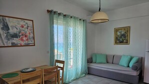 Un salon comprenant une table à manger, des chaises, un canapé et un tableau accroché au mur.