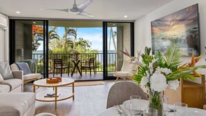 Ein modernes Wohnzimmer mit Balkon, Essbereich und einem Gemälde an der Wand.