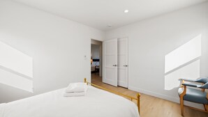 Quarto com uma cama, uma cadeira e um guarda-roupa.