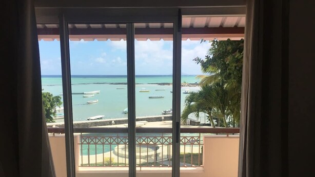 Un balcón con vista al mar y a barcos.