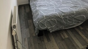 A small, neatly arranged bedroom with a single bed, a radiator, and a window with curtains. - House rental for 24h of Le Mans, Le Mans Classic and Grand Prix events (Parigné-l'Évêque)